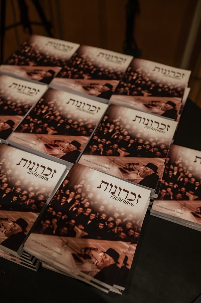 Stacks of printed Zichronos copies on a table